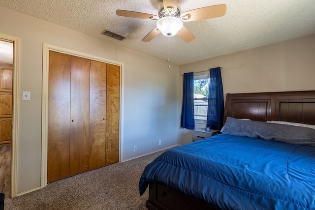 carpeted bedroom featuring a closet, ceiling fan, and a textured ceiling