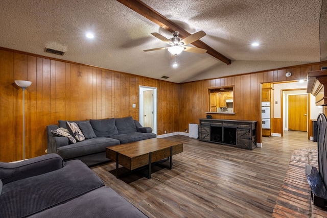 living room featuring a textured ceiling, wood walls, ceiling fan, and hardwood / wood-style flooring