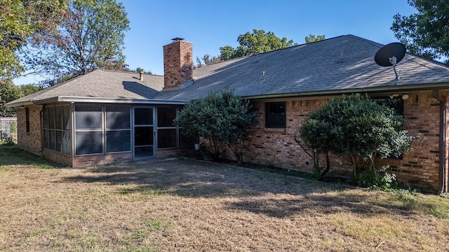 rear view of property featuring a sunroom and a yard