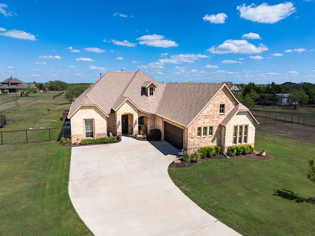 french provincial home with a front yard and a garage