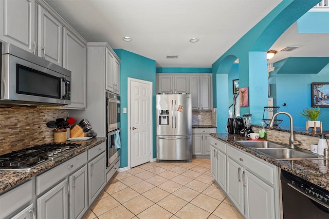 kitchen with stainless steel appliances, light tile patterned floors, sink, and tasteful backsplash