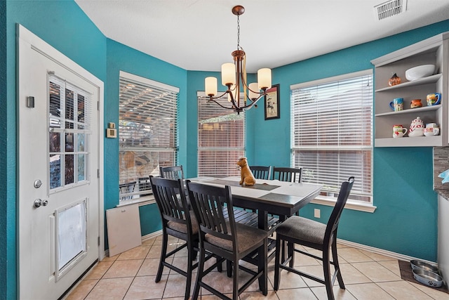 tiled dining area with a chandelier