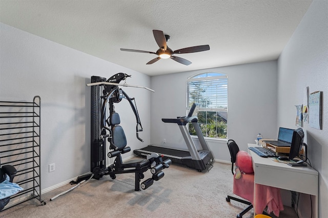 workout area featuring a textured ceiling, carpet floors, and ceiling fan