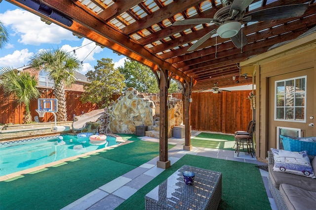 view of swimming pool featuring a patio area, ceiling fan, and a water slide