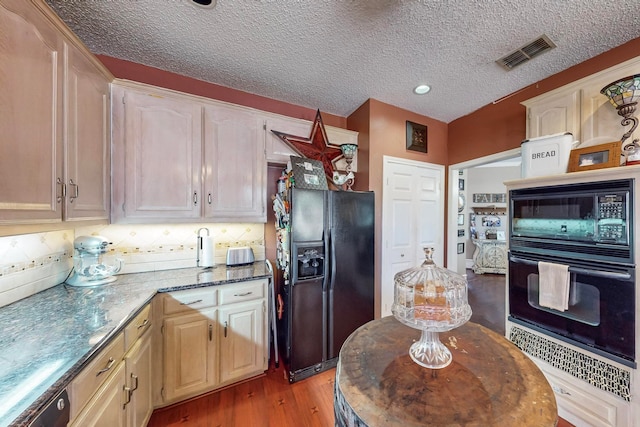 kitchen featuring light stone counters, a textured ceiling, light hardwood / wood-style flooring, backsplash, and black appliances