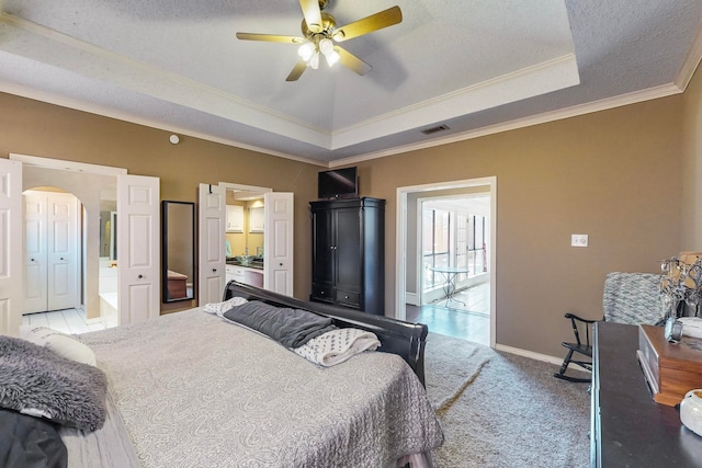 bedroom featuring ceiling fan, a textured ceiling, crown molding, and light carpet