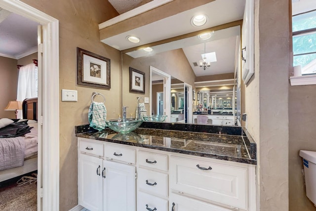 bathroom featuring vaulted ceiling, crown molding, vanity, and toilet