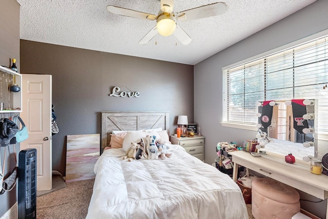 bedroom featuring ceiling fan, light colored carpet, and a textured ceiling