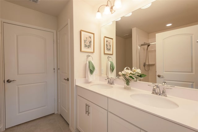 bathroom with a shower, tile patterned flooring, and vanity