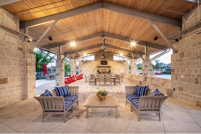 view of patio with an outdoor living space with a fireplace and a gazebo