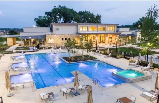 view of swimming pool with a patio, pool water feature, and a hot tub