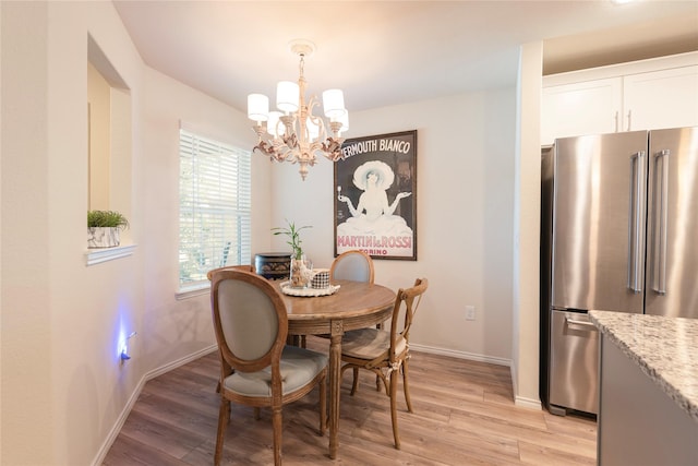 dining space with a chandelier and light wood-type flooring