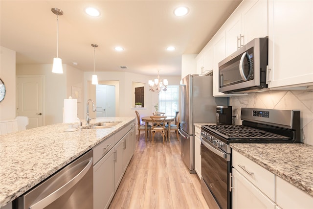 kitchen featuring white cabinetry, pendant lighting, and appliances with stainless steel finishes