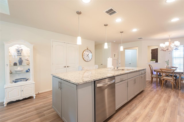 kitchen featuring gray cabinets, a kitchen island with sink, dishwasher, and sink