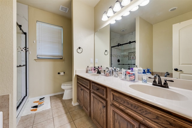 bathroom with vanity, toilet, a shower with door, and tile patterned floors