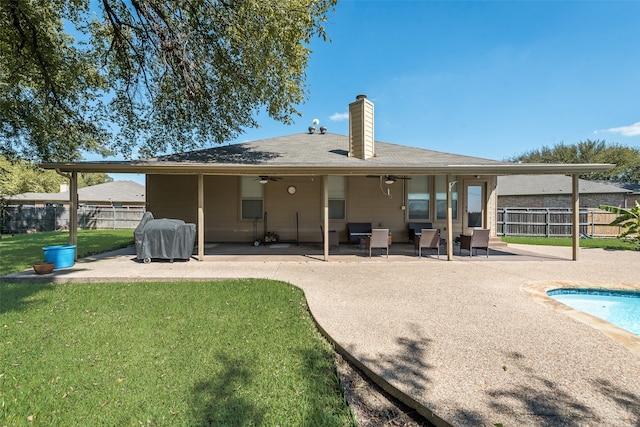 back of property with a lawn, a patio, a fenced in pool, and ceiling fan