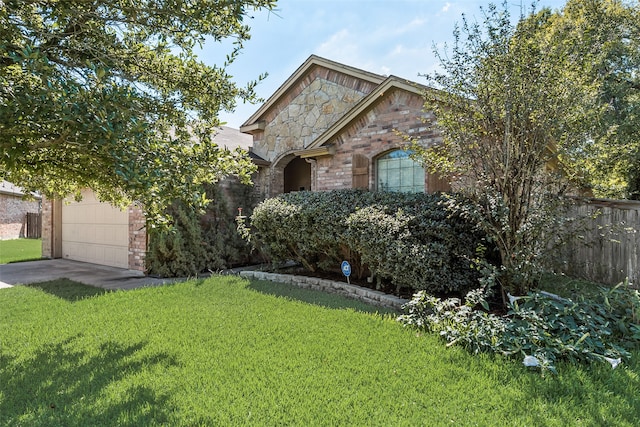 view of property hidden behind natural elements featuring a front yard and a garage