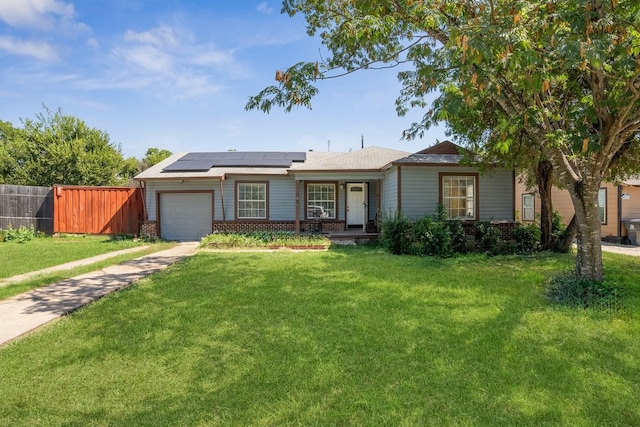 ranch-style home with a front yard, solar panels, and a garage