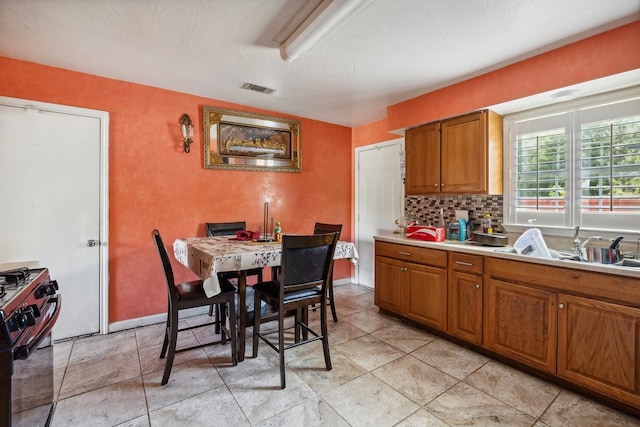 kitchen featuring gas stove and tasteful backsplash