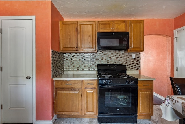 kitchen featuring black appliances and tasteful backsplash