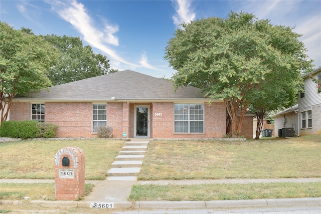 view of front of house with a front lawn and central air condition unit