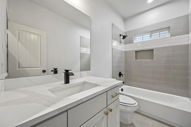 full bathroom with tile patterned floors, tiled shower / bath, vanity, and toilet