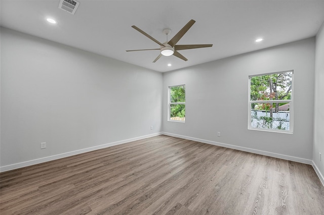 unfurnished room with hardwood / wood-style flooring, ceiling fan, and a wealth of natural light