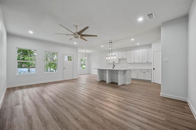 unfurnished living room with light wood-type flooring and ceiling fan