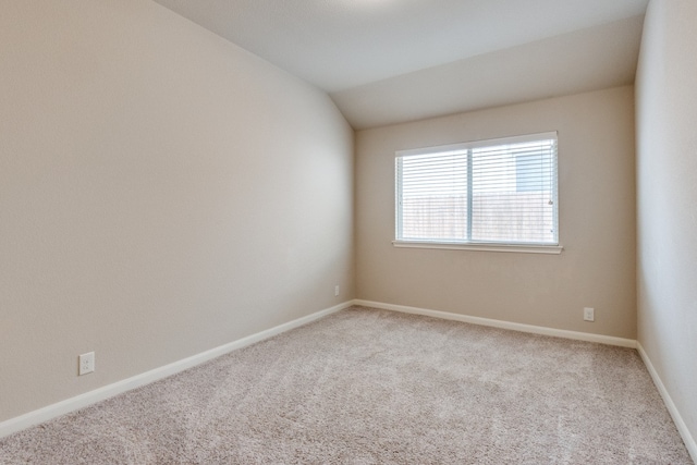 unfurnished room featuring carpet floors and lofted ceiling