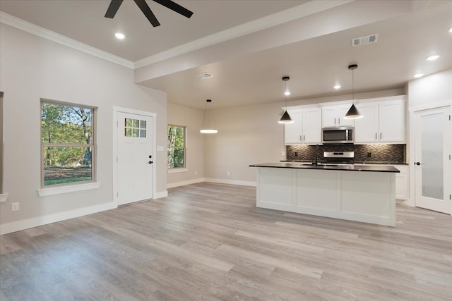 kitchen featuring appliances with stainless steel finishes, light hardwood / wood-style flooring, plenty of natural light, and white cabinets