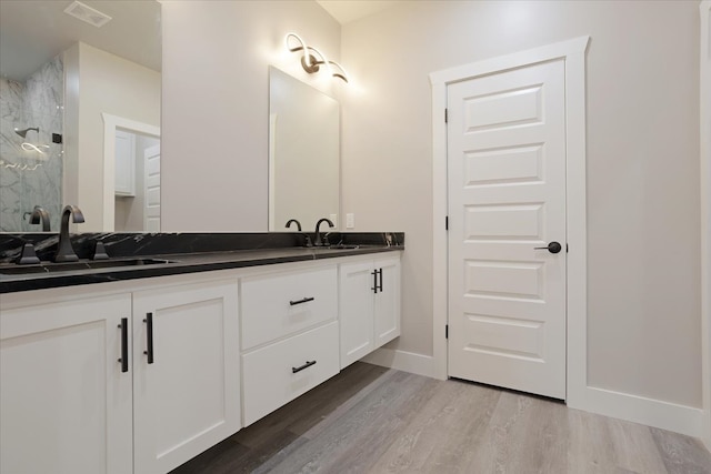 bathroom with vanity, walk in shower, and wood-type flooring