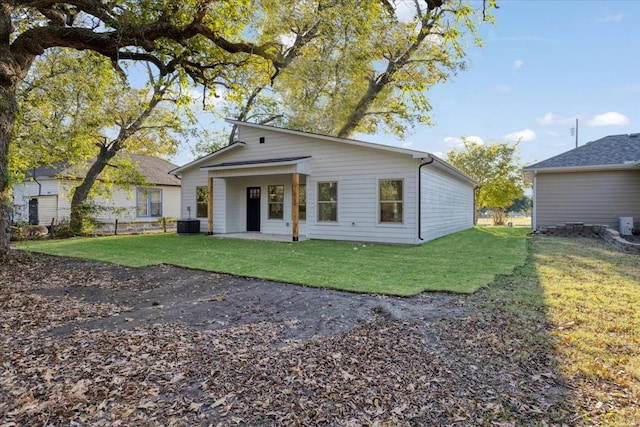 view of front of property featuring a patio area, a front yard, and cooling unit