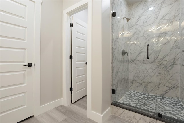 bathroom featuring a shower with door and wood-type flooring