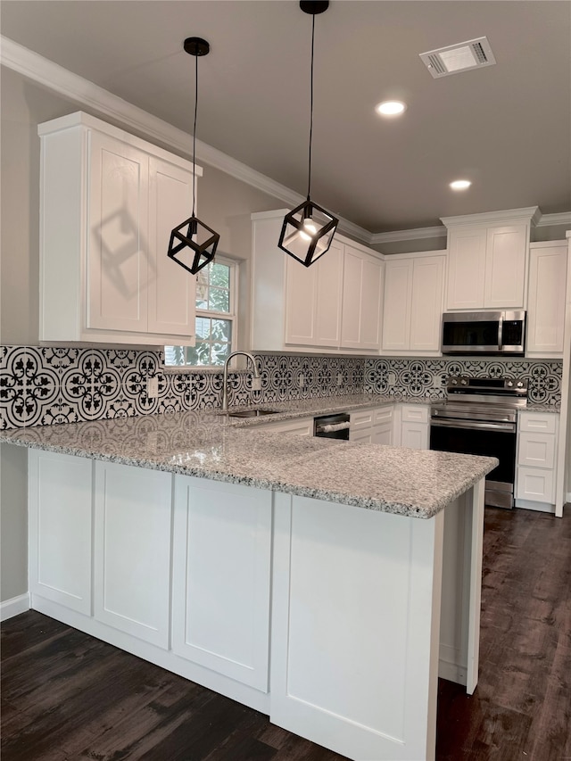 kitchen featuring light stone countertops, sink, appliances with stainless steel finishes, and kitchen peninsula