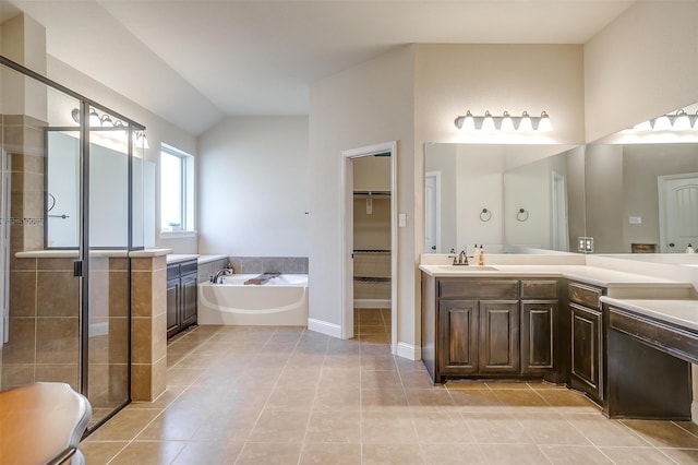 bathroom featuring shower with separate bathtub, lofted ceiling, vanity, and tile patterned floors