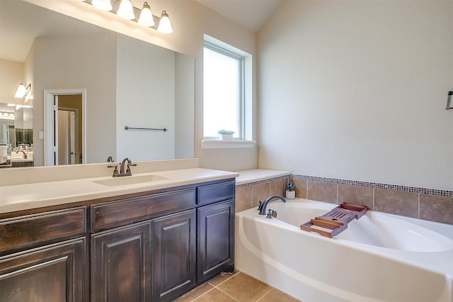 bathroom with a bathtub, lofted ceiling, vanity, and tile patterned flooring