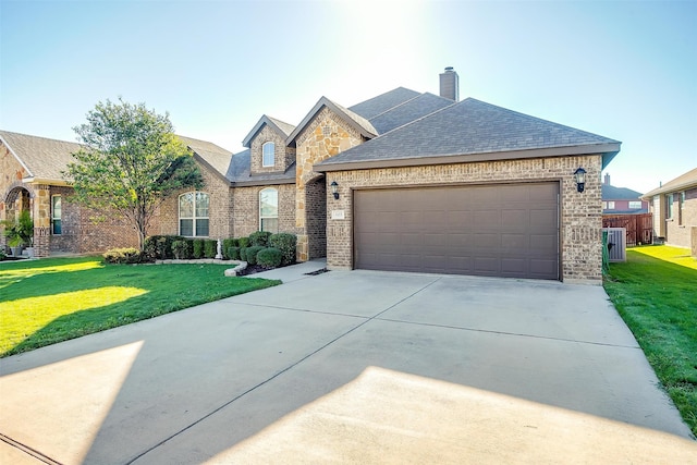 view of front facade featuring a garage, a front lawn, and central AC unit