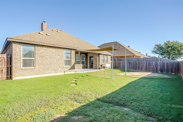 rear view of property with a patio and a yard