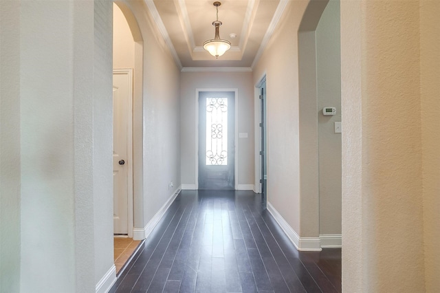 doorway to outside featuring a tray ceiling, dark hardwood / wood-style floors, and crown molding