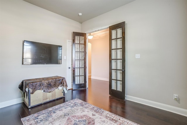 bedroom featuring french doors and dark hardwood / wood-style flooring