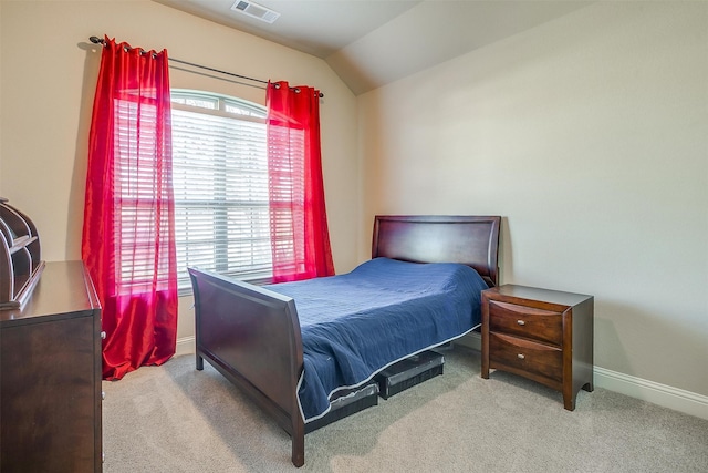 bedroom featuring light colored carpet and vaulted ceiling