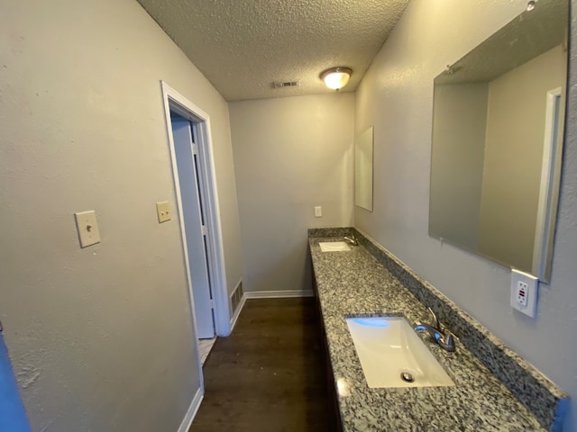 hall featuring a textured ceiling, sink, and dark hardwood / wood-style flooring