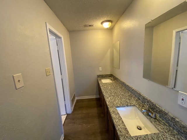 bathroom featuring a textured ceiling, hardwood / wood-style flooring, and vanity