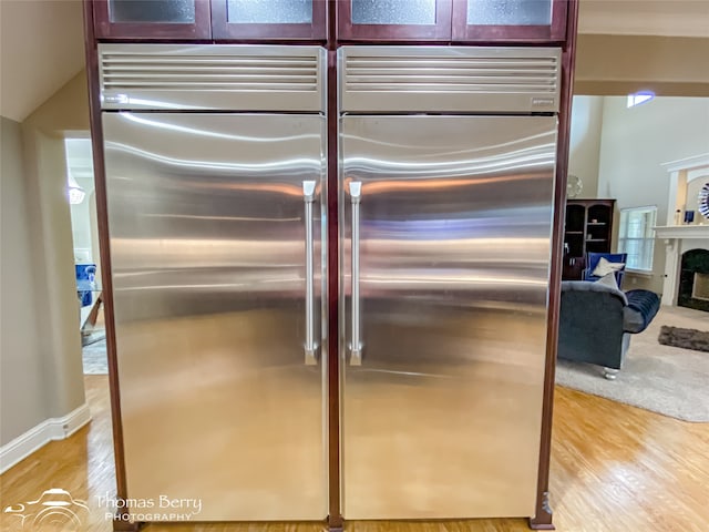 room details featuring stainless steel built in fridge and light wood-type flooring