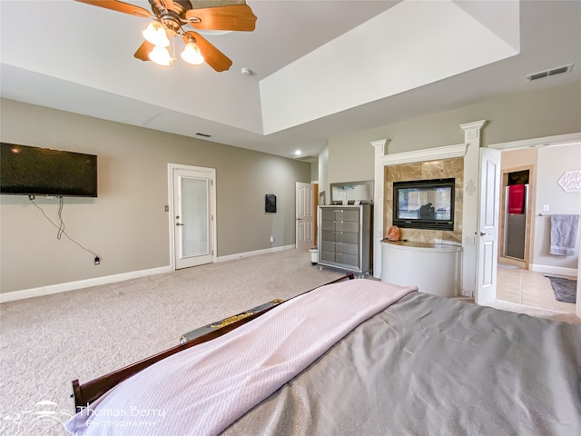 bedroom featuring ceiling fan, light colored carpet, and ensuite bath