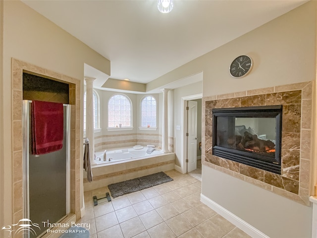 bathroom featuring tile patterned flooring, a multi sided fireplace, and plus walk in shower