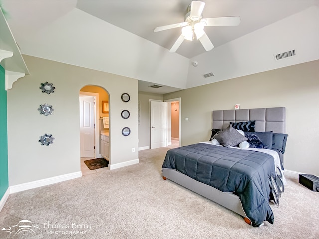 carpeted bedroom featuring vaulted ceiling, ceiling fan, and ensuite bathroom