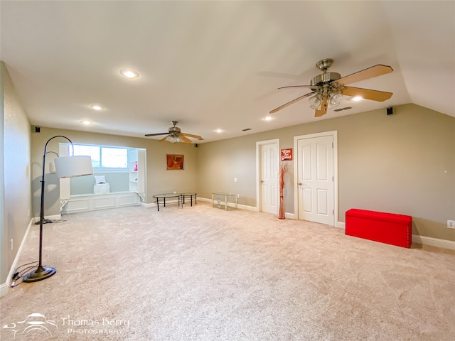 interior space with ceiling fan, carpet floors, and vaulted ceiling