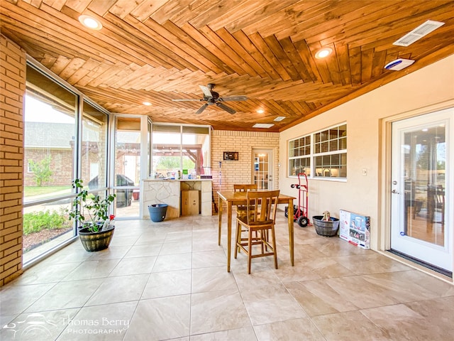 sunroom with ceiling fan, wood ceiling, and a healthy amount of sunlight