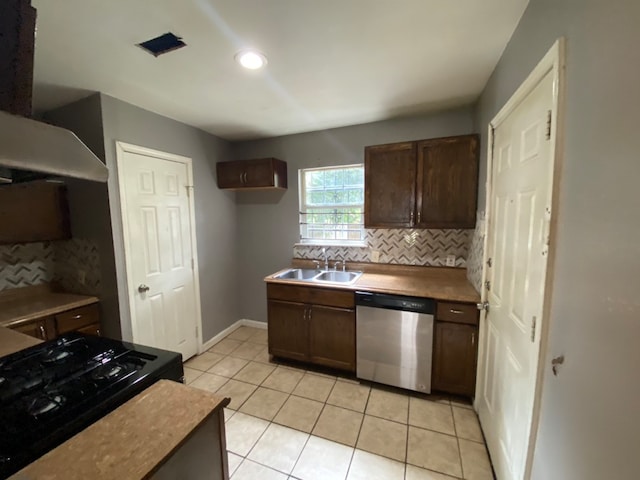 kitchen with dark brown cabinets, sink, backsplash, light tile patterned floors, and stainless steel dishwasher